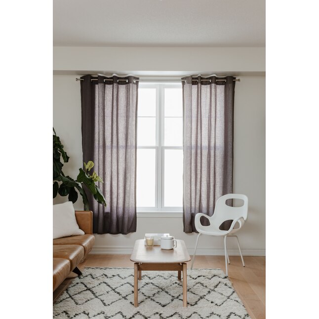 Umbra Cappa curtain rod set up in living room with black sheer curtains.