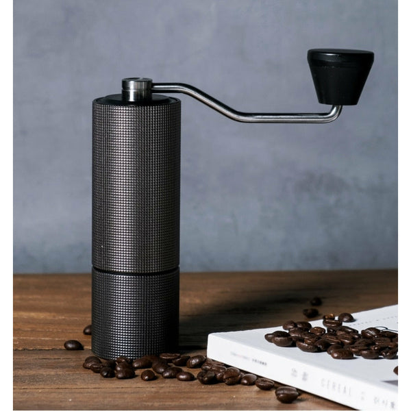 Timemore Chestnut C2 Coffee Grinder, posed with coffee beans on a table.