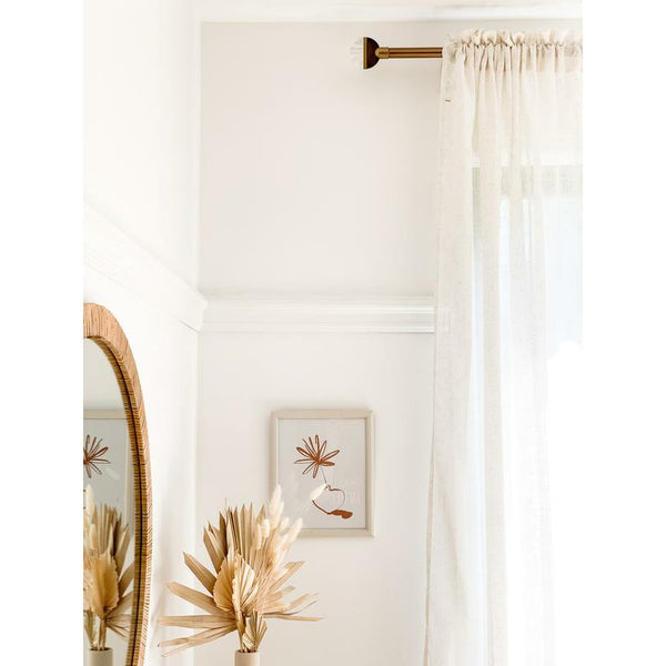 Umbra Lolly Curtain rod used in a light coloured room with a sheer white curtain attached.